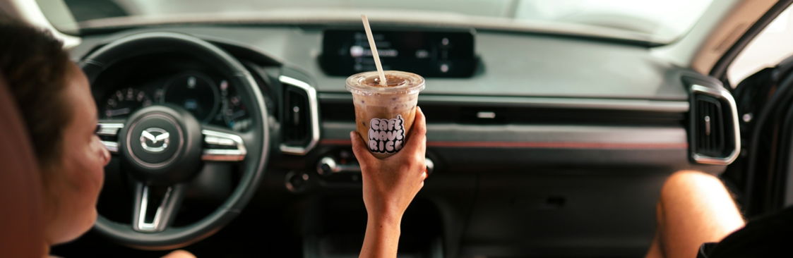 woman-holding-coffee-drink-inside-car.jpg Woman holding coffee drink inside car